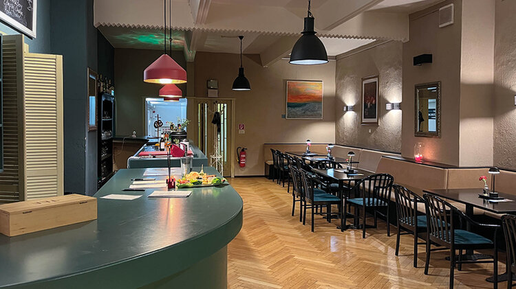Die Theaterbar in Halberstadt. Grüner Tresen und heller Boden mit Sitzgelegenheiten und Tischen